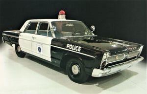 1966 Plymouth Fury Police Car, with a black front and back, and white doors. A red light sits atop the car.