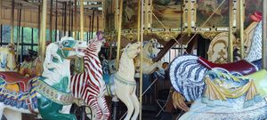 the carousel in Golden Gate park, with colorful animals for seats, such as horses, zebras, chicken, and dragons