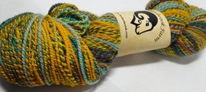 Wool yarn, wound in a hank, twisted into a brain style. The strands wrap around each other, and vary in color from deep orange, bright blue, dull gray, and bold yellow.