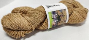 Alpaca yarn wound in a hank, in the fiber's natural medium tan color.